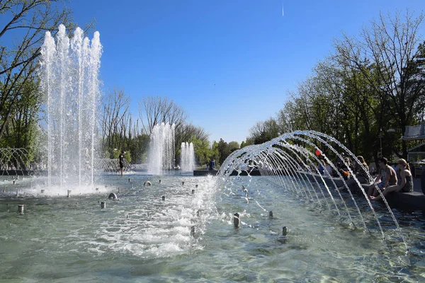 Fonte da cidade na cidade de Krasnodar. As pessoas estão a passar pela fonte. Salpicos de água . — Fotografia de Stock