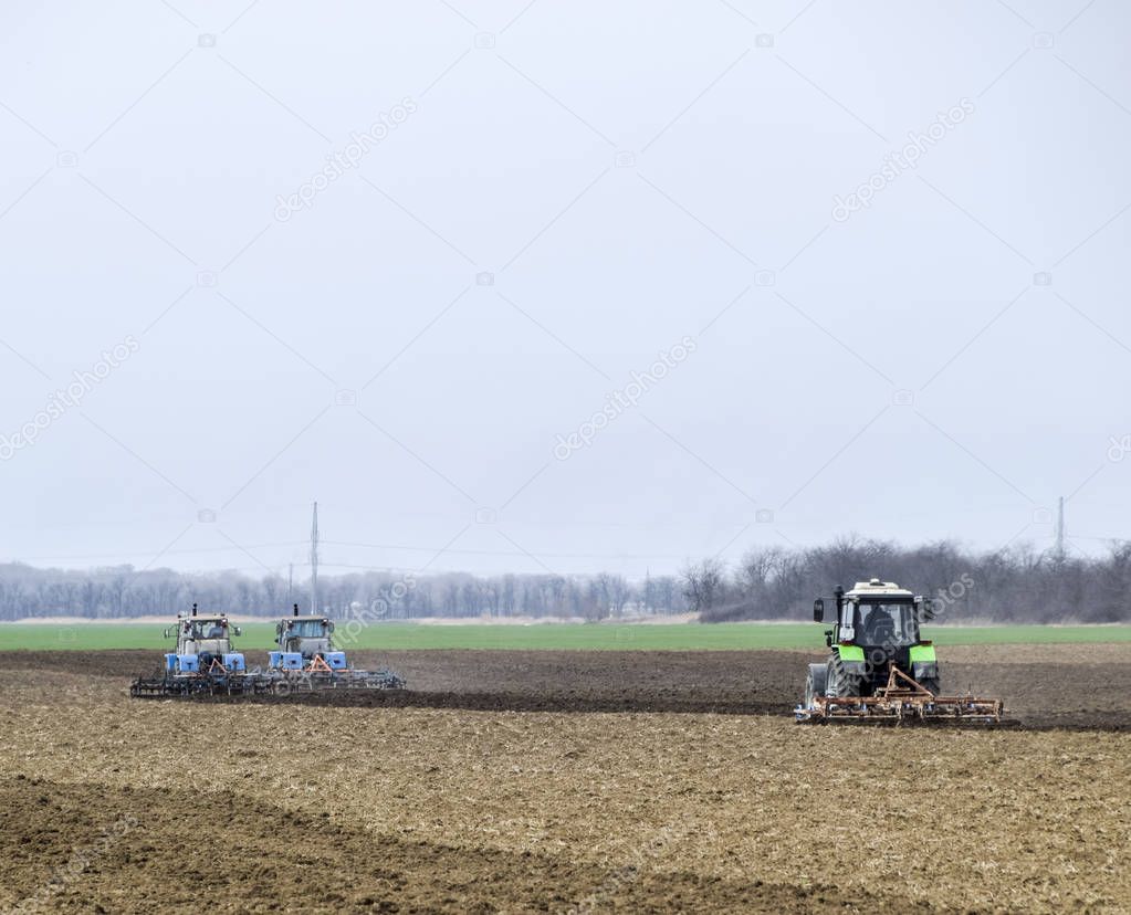 Lush and loosen the soil on the field before sowing. The tractor plows a field with a plow.