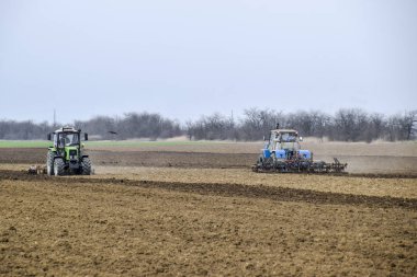 Gür ve Ekim önce toprak sahada gevşetin. Traktör bir alan ile bir pulluk pulluklar.