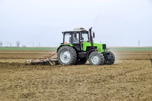 Bujna i spulchniają glebę, na pola przed siewem. Traktor orze pole z pług — Zdjęcie stockowe
