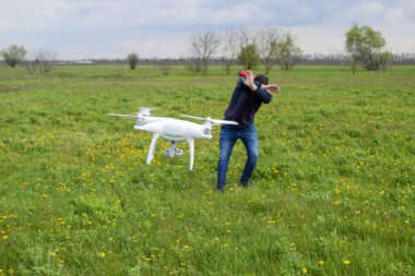 Bir adam kendini bir dron ile bir çarpışma dan gizler. Quadrocopter kişiye uçar