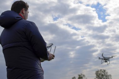 Bir adam elinde bir uzaktan kumanda ile. Gökyüzüne karşı drone uçuş kontrol. Hayalet