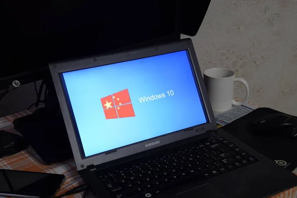 Ordenador portátil con el logotipo del sistema operativo que se muestra en la pantalla Windows 10 . — Foto de Stock