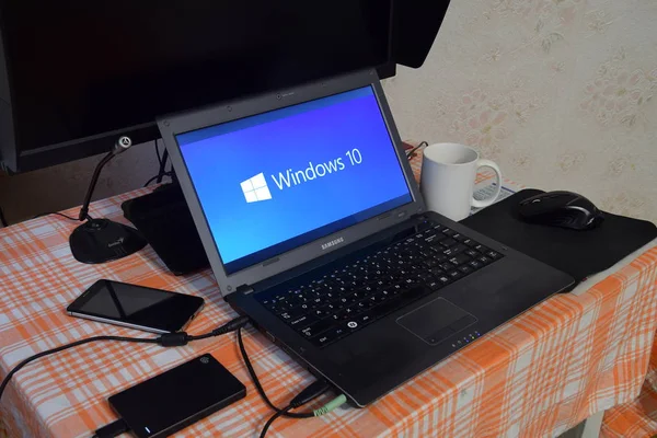 Ordenador portátil con el logotipo del sistema operativo que se muestra en la pantalla Windows 10 . — Foto de Stock