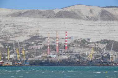 Uluslararası liman. Kargo bağlantı noktası bağlantı noktası ile vinç. Deniz defne ve dağlık sahil.