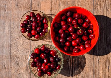 Plastik bardaktaki ahşap arka planda tatlı kirazlar. Olgun kırmızı tatlı kiraz