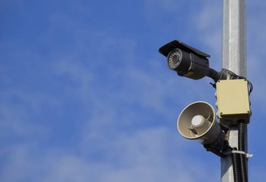 CCTV kamera ve hoparlör alarm kutup mavi gökyüzü karşı.