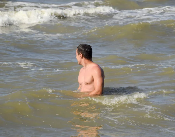 ชายน ฬาในน าทะเล การอาบน าในทะเล ชายคนหน ายน ามกลางคล นของทะเล — ภาพถ่ายสต็อก