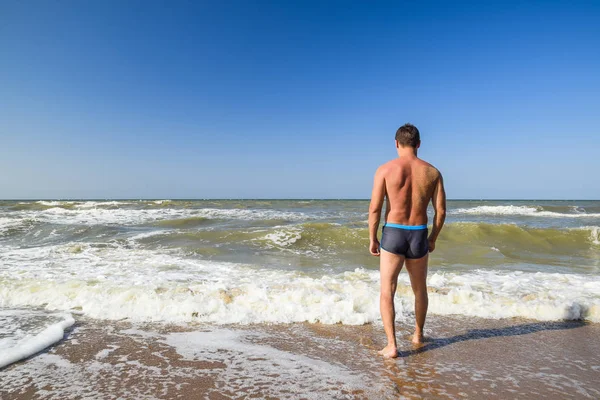 ชายน ฬาบนชายหาด ชายคนหน งลงไปในน าทะเล — ภาพถ่ายสต็อก