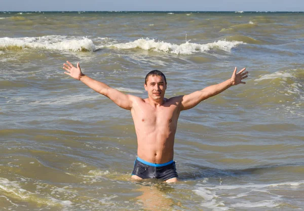 sports man comes out of the sea water. Bathing in the sea. A man is swimming among the waves of the sea.