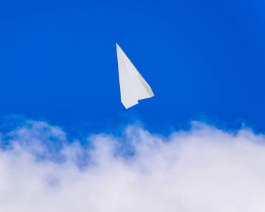 Mavi gökyüzünde bulutlar ile beyaz kağıt uçak. Messenger ileti simgesi