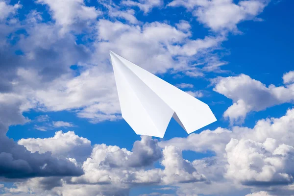 White paper airplane in a blue sky with clouds. The message symbol in the messenger