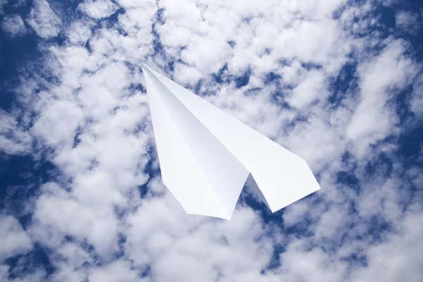 White paper airplane in a blue sky with clouds. The message symbol in the messenger