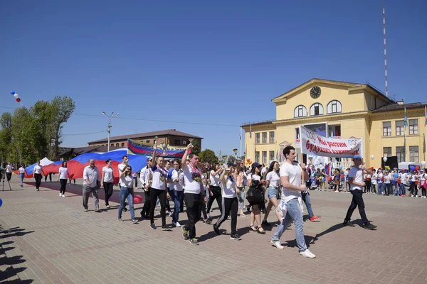 Solemne portación de la bandera de Rusia por zona. Celebrando el primero de mayo, el día de la primavera y el trabajo. Desfile del Primero de Mayo en la Plaza del Teatro en la ciudad de Slavyansk-on-Kuban . — Foto de Stock
