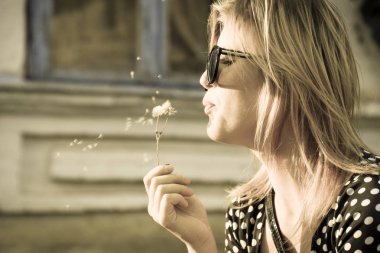 Kız bir karahindiba üzerinde üfleme. Karahindiba tohumları üfleme