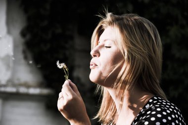 Kız bir karahindiba üzerinde üfleme. Karahindiba tohumları üfleme