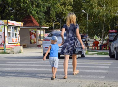 Krasnodar, Rusya Federasyonu - 28 Ağustos 2017: Anne ve oğlu bir yaya geçidi üzerinde karşıdan karşıya. Trafik güvenliği