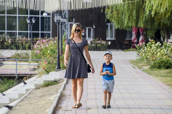 Anne ve oğlu parkta yürüyorlar. Aile yürüyüş