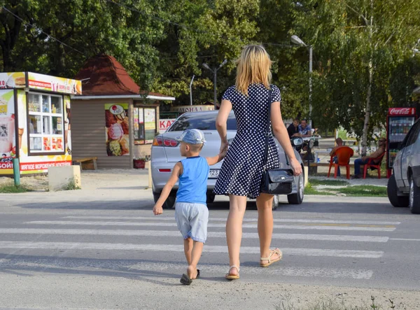 Krasnodar, Rusya Federasyonu - 28 Ağustos 2017: Anne ve oğlu bir yaya geçidi üzerinde karşıdan karşıya. Trafik güvenliği
