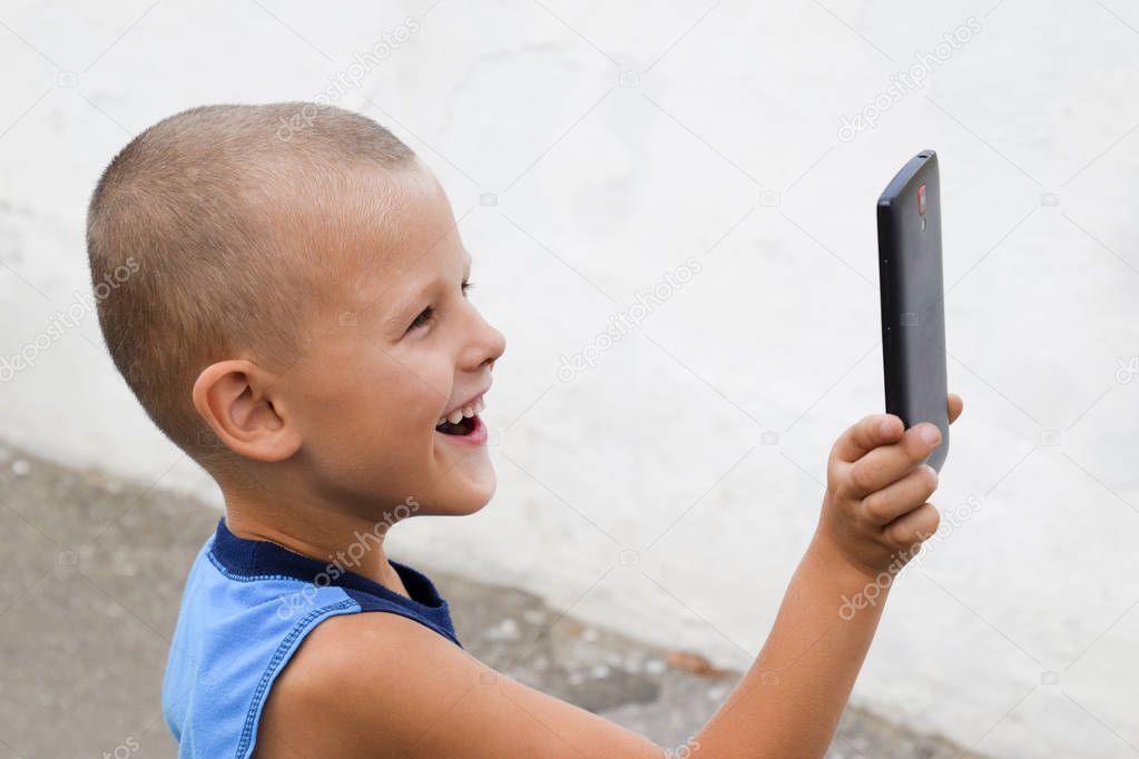 Child with a smartphone. A little boy shoots video on a smartphone.
