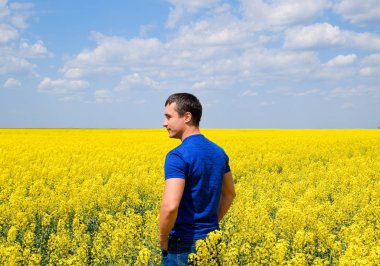 Bir adam bir mavi T-shirt kanola alan yürüyor