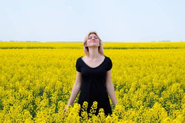 Alanındaki çiçekli tecavüz, siyah elbiseli bir kız