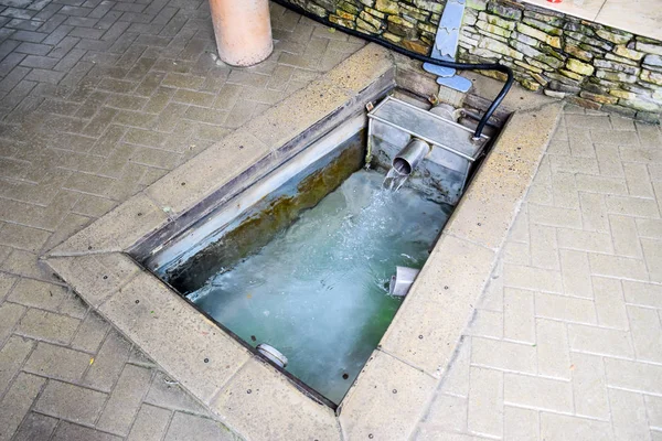 En liten pool med heligt vatten från våren. En nisch i golvet för att rekrytera vatten från en källa — Stockfoto