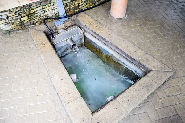 En liten pool med heligt vatten från våren. En nisch i golvet för att rekrytera vatten från en källa — Stockfoto