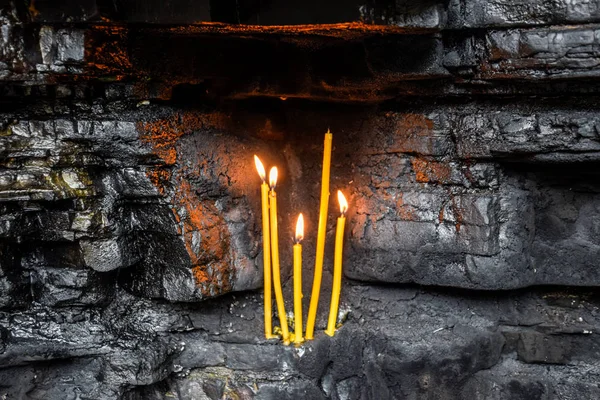 Bougies d'église en cire dans des niches rocheuses. Lieu saint — Photo