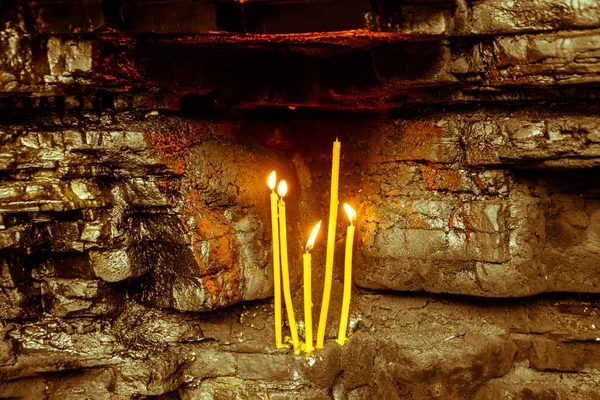 Bougies d'église en cire dans des niches rocheuses. Lieu saint — Photo