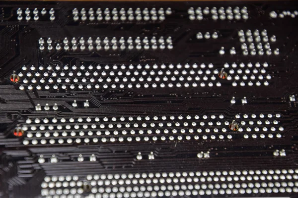 The reverse side of the microboard. Contacts solder. Soldered parts. Electronic board with electrical components. Electronics of computer equipment