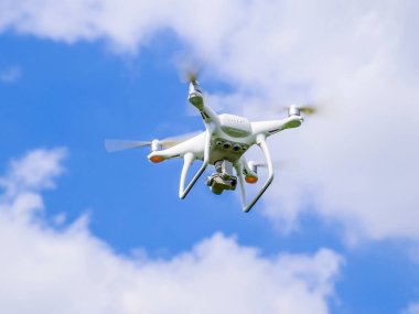 Uçuş quadrocopters beyaz bulutlar ile mavi gökyüzüne karşı