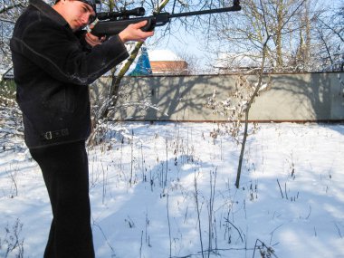 adam ile bir kış parkta bir havalı tüfek.