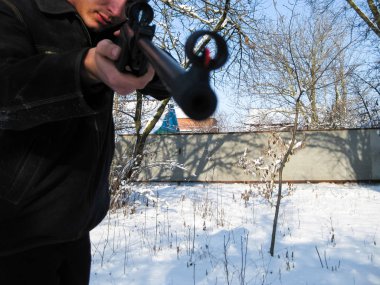 adam ile bir kış parkta bir havalı tüfek.