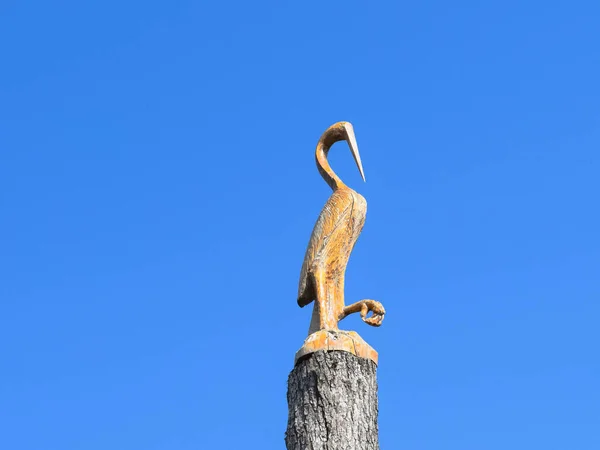 Figura di gru sul ceppo di un albero contro il cielo blu. Fig. — Foto Stock
