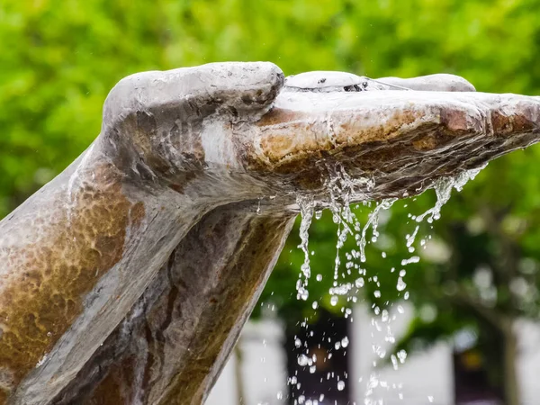 Mãos estátua da qual a água flui. Monumento decoração no — Fotografia de Stock