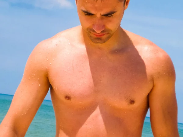Męskiego torsu. Mięśni młody człowiek stoi na plaży. — Zdjęcie stockowe