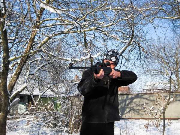 Людина з пневматичною гвинтівкою в зимовому парку . — стокове фото