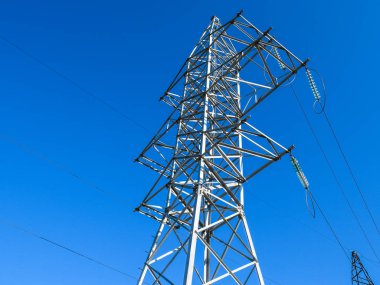 Yüksek voltajlı elektrik hatları mavi gökyüzü destekler