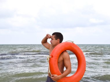 Adam bir lifebuoy ile sahilde