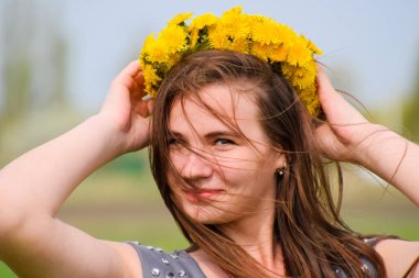 Bir kızla dandelions başında bir çelenk. Güzel peri
