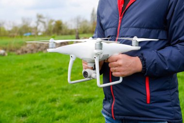 Quadrocopter onun elinde olan bir adam. Beyaz bir dron p ediliyor