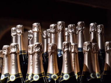 Tezgahta bir şişe şampanya. Şarap ve şampiyon rafları.