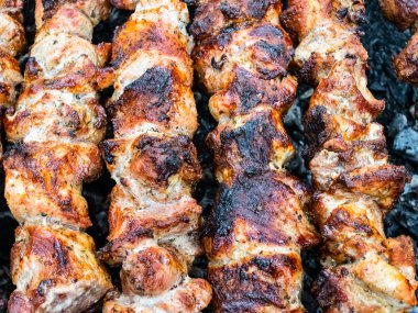 Brezilya şiş üzerinde domuz kızartması yemek. Kömürün üstünde et çeviriyorum..