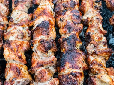 Brezilya şiş üzerinde domuz kızartması yemek. Kömürün üstünde et çeviriyorum..