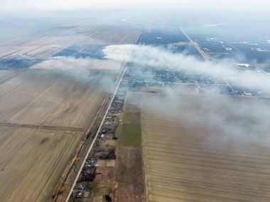 Küçük köyün üst görünümü. Saman yanan duman i