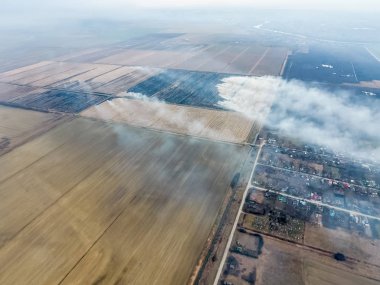 Küçük köyün üst görünümü. Saman yanan duman i