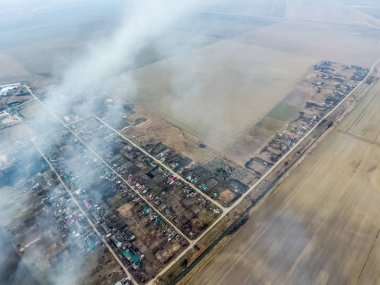Küçük köyün üst görünümü. Saman yanan duman i