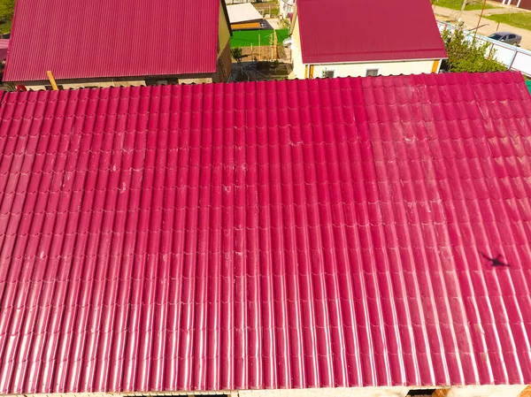 A house with a red roof made of corrugated metal sheets. Roof fr — Stock Photo, Image