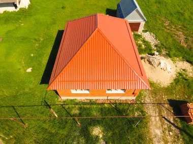 Üst manzaralı, metalden yapılmış turuncu çatılı bir ev. Metalik prof